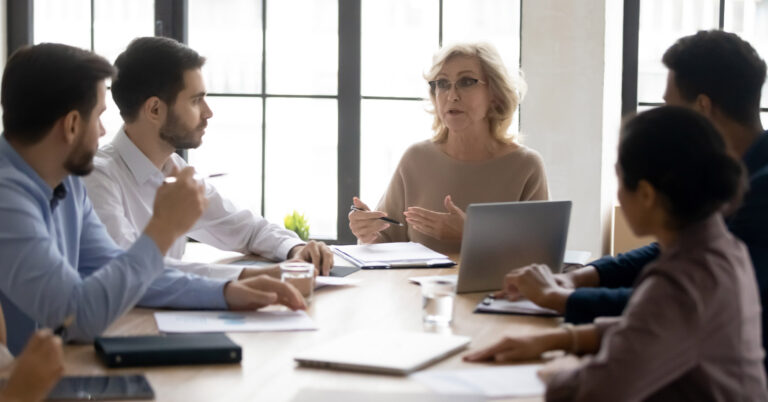 Coworkers gather around a conference table to conduct an active shooter tabletop exercise