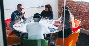 Workers sit around table